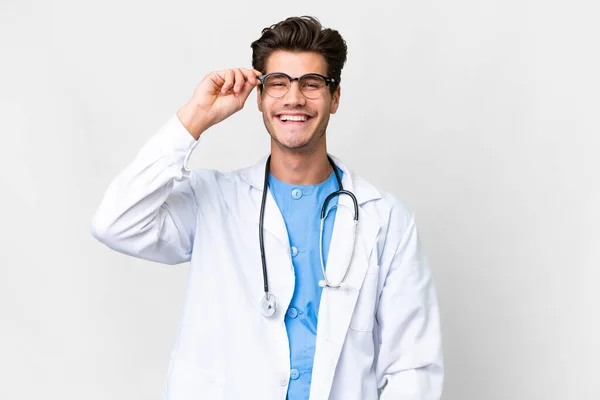 年轻的医生 带着眼镜 快乐地越过孤独的白色背景 — 图库照片