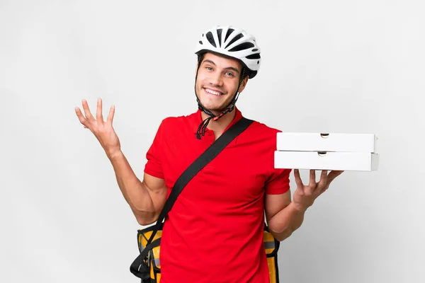 stock image Pizza delivery man with work uniform picking up pizza boxes over isolated white background extending hands to the side for inviting to come