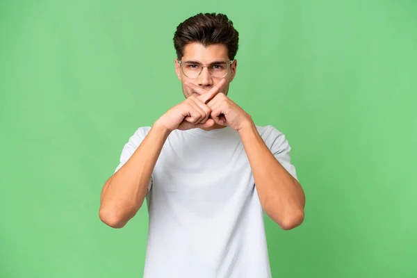 stock image Young caucasian handsome man over isolated background showing a sign of silence gesture