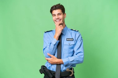 Soyutlanmış geçmişinde gülümseyen genç bir polis.