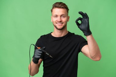 Dövme sanatçısı beyaz adam izole edilmiş arka planda tamam işareti parmaklarıyla gösteriyor