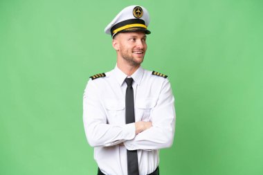 Uçak pilotu arka planda mutlu ve gülümsüyor.