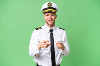 Uçak pilotu izole edilmiş arka planda ön tarafı gösteriyor ve gülümsüyor.