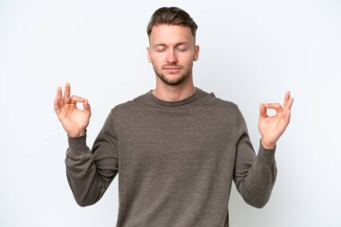 Zen pozisyonunda beyaz arka planda izole edilmiş genç sarışın beyaz adam.