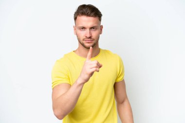 Beyaz arka planda izole edilmiş genç sarışın adam hayal kırıklığına uğramış ve ön tarafı işaret ediyor.