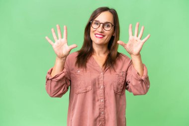 Orta yaşlı beyaz kadın tecrit edilmiş arka planda on parmaklı sayım yapıyor.