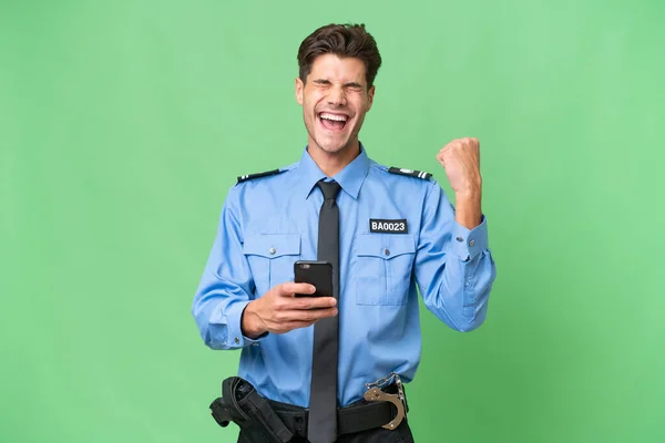 Jovem Policial Sobre Fundo Isolado Com Telefone Posição Vitória — Fotografia de Stock