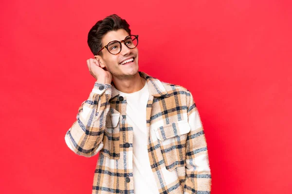 stock image Young caucasian handsome man isolated on red background thinking an idea