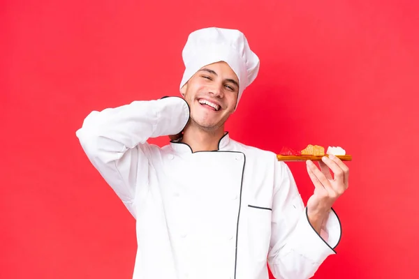 Junger Kaukasischer Koch Hält Sashimi Isoliert Auf Rotem Hintergrund Und — Stockfoto