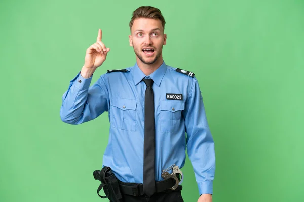 指を持ち上げながら解決策を実現しようとする孤立した背景を持つ若い警察官 — ストック写真