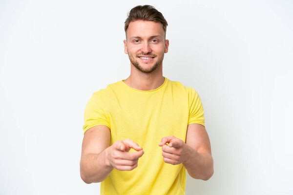 Young blonde caucasian man isolated on white background pointing to the front and smiling