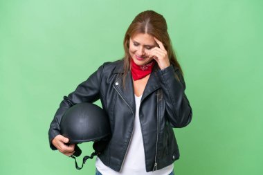 Motosiklet kasklı orta yaşlı beyaz bir kadın izole edilmiş arka planda gülüyor.