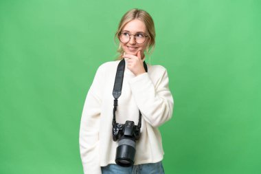 Young photographer English woman over isolated background having doubts and with confuse face expression