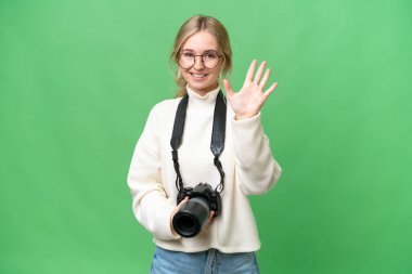 Genç fotoğrafçı İngiliz kadın tecrit edilmiş arka planda beş parmaklı sayım yapıyor.