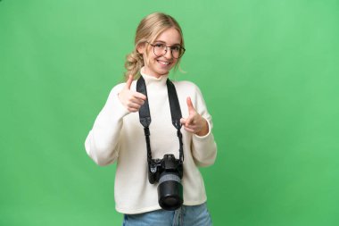 Genç fotoğrafçı İngiliz kadın izole edilmiş arka planda ön tarafı gösteriyor ve gülümsüyor.