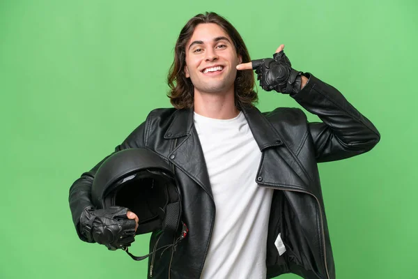 若いですハンサムな男とともにオートバイヘルメット隔離上の緑色の背景与えます親指アップジェスチャー — ストック写真