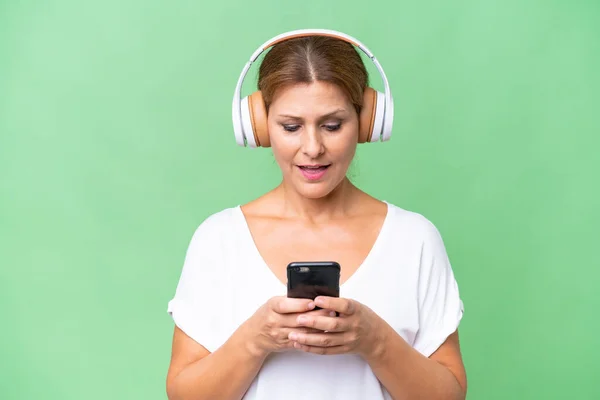 Donna Caucasica Mezza Età Musica Ascolto Sottofondo Isolata Guardando Cellulare — Foto Stock