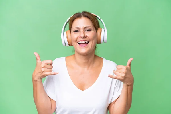 Μεσήλικη Καυκάσια Γυναίκα Απομονωμένο Φόντο Ακούγοντας Μουσική Κάνοντας Ροκ Χειρονομία — Φωτογραφία Αρχείου