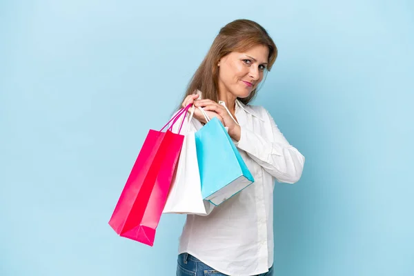 青地に隔離された中年の白人女性ショッピングバッグ — ストック写真