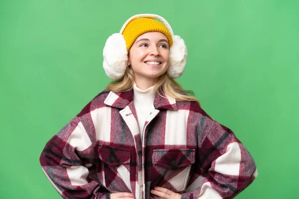 Młoda Angielka Ubrana Zimowe Mufy Odizolowanym Tle Pozująca Rękami Biodrach — Zdjęcie stockowe