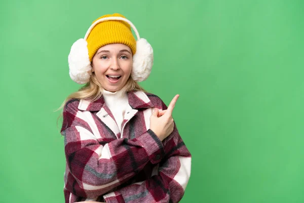 Young English Woman Wearing Winter Muffs Isolated Background Surprised Pointing — Fotografia de Stock