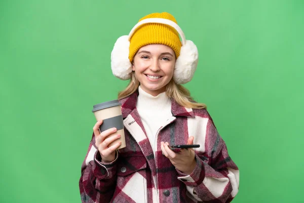 Young English Woman Wearing Winter Muffs Isolated Background Holding Coffee — Stock Photo, Image