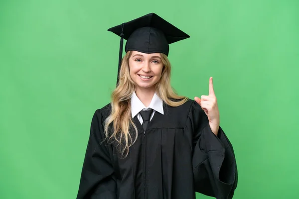 Junge Englische Universitätsabsolventin Mit Isoliertem Hintergrund Zeigt Und Hebt Einen — Stockfoto
