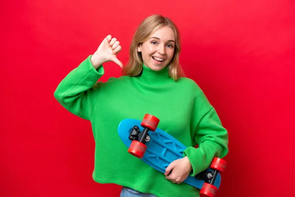 若い英語の女性は幸せな表情でスケートで赤の背景に隔離されました — ストック写真