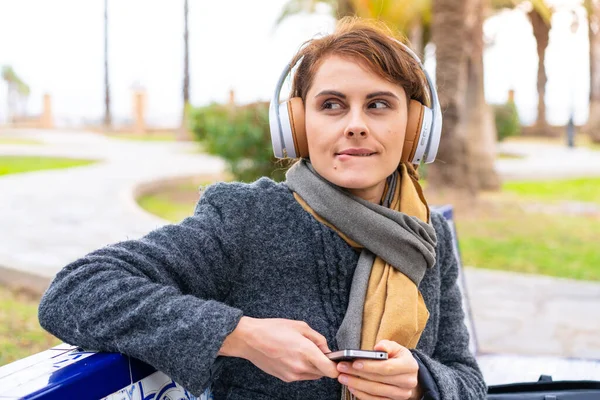 Μελαχρινή Γυναίκα Εξωτερικούς Χώρους Ακούγοντας Μουσική Ένα Κινητό Και Σκέψης — Φωτογραφία Αρχείου