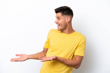 Beyaz arka planda beyaz tenli genç bir adam sürpriz bir ifadeyle yan yana bakarken...