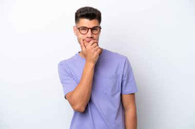 Beyaz arka planda soyutlanmış genç beyaz bir adamın şüpheleri var.