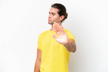 Beyaz arka planda izole edilmiş beyaz yakışıklı adam dur hareketi yapıyor ve hayal kırıklığına uğruyor.