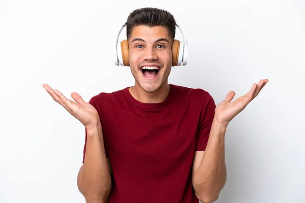 Νεαρός Καυκάσιος Άνδρας Απομονωμένος Λευκό Φόντο Έκπληκτος Και Ακούγοντας Μουσική — Φωτογραφία Αρχείου