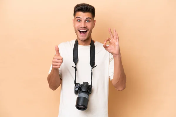Νεαρός Φωτογράφος Καυκάσιος Άνδρας Απομονωμένος Μπεζ Φόντο Που Δείχνει Εντάξει — Φωτογραφία Αρχείου