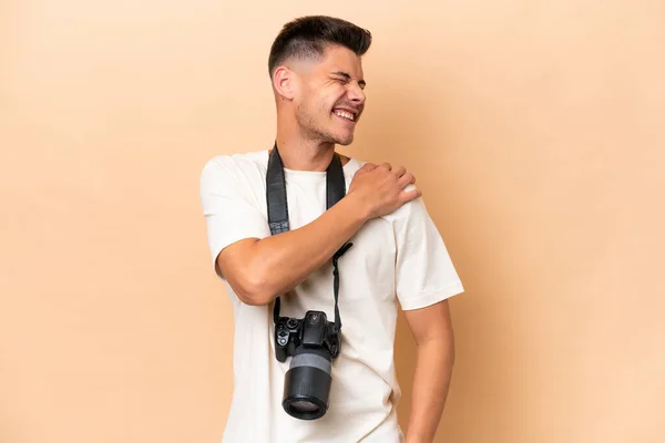 Genç Fotoğrafçı Bej Arka Planda Izole Edilmiş Omuz Ağrısından Muzdarip — Stok fotoğraf