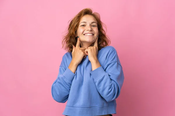幸せな気持ちの良い表情で笑顔ピンクの背景に隔離された若いグルジアの女性 — ストック写真