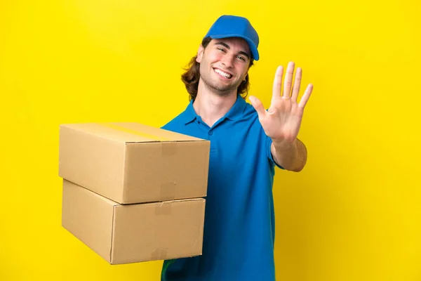 stock image Delivery handsome man isolated on yellow background counting five with fingers