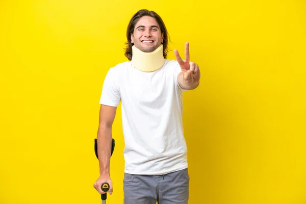 Young Handsome Man Wearing Neck Brace Crutches Isolated Yellow Background —  Fotos de Stock
