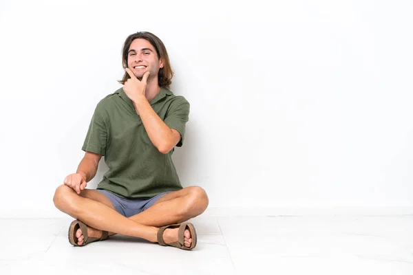 Junger Gutaussehender Mann Sitzt Isoliert Auf Dem Boden Vor Weißem — Stockfoto