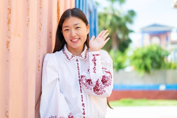 Ung Kinesisk Kvinna Utomhus Saluterar Med Handen Med Glada Uttryck — Stockfoto
