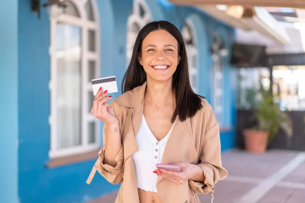 Dışarıda Kredi Kartıyla Cep Telefonuyla Alışveriş Yapan Genç Bir Kadın — Stok fotoğraf