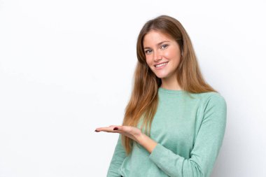 Beyaz arka planda izole edilmiş genç beyaz kadın bir fikir sunuyor ve gülümsüyor.