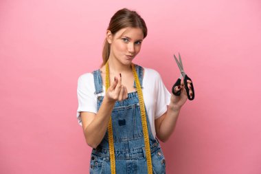 Pembe arka planda izole edilmiş beyaz kadın para hareketi yapıyor.