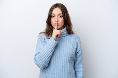 Beyaz arka planda izole edilmiş beyaz bir kadın sessiz bir jest işareti gösteriyor. Parmağını ağzına sokuyor.