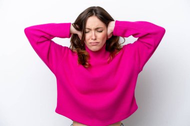 Beyaz arka planda izole edilmiş genç beyaz kadın hayal kırıklığına uğramış ve kulaklarını kapatmış.