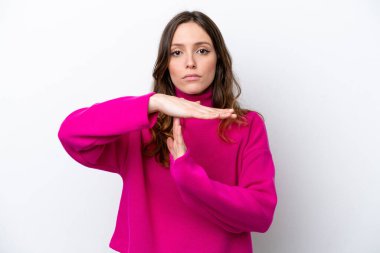 Beyaz arka planda izole edilmiş genç beyaz bir kadın zaman aşımı hareketi yapıyor.