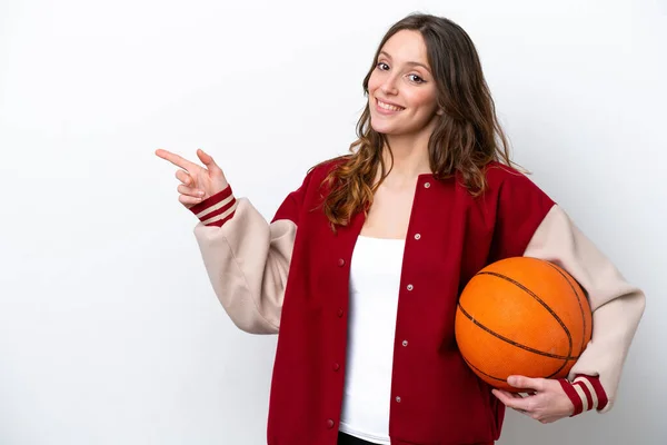 若いですCaucasian女性プレーバスケットボール孤立した上に白い背景指差し指へ側 — ストック写真
