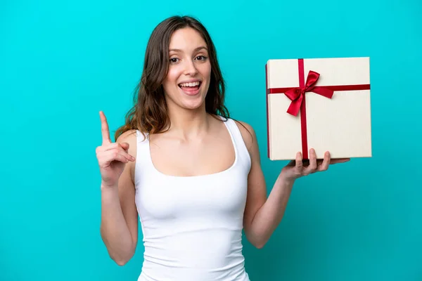 Young Caucasian Woman Holding Gift Isolated Blue Background Pointing Great —  Fotos de Stock