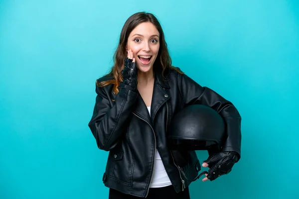 若いですCaucasian女性とともにオートバイヘルメット隔離上の青の背景で驚きとショックを受けた顔の式 — ストック写真