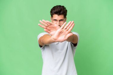 Kafkasyalı yakışıklı, soyutlanmış bir geçmişi olan genç bir adam bir eylemi durdurmak için el hareketini durduruyor.